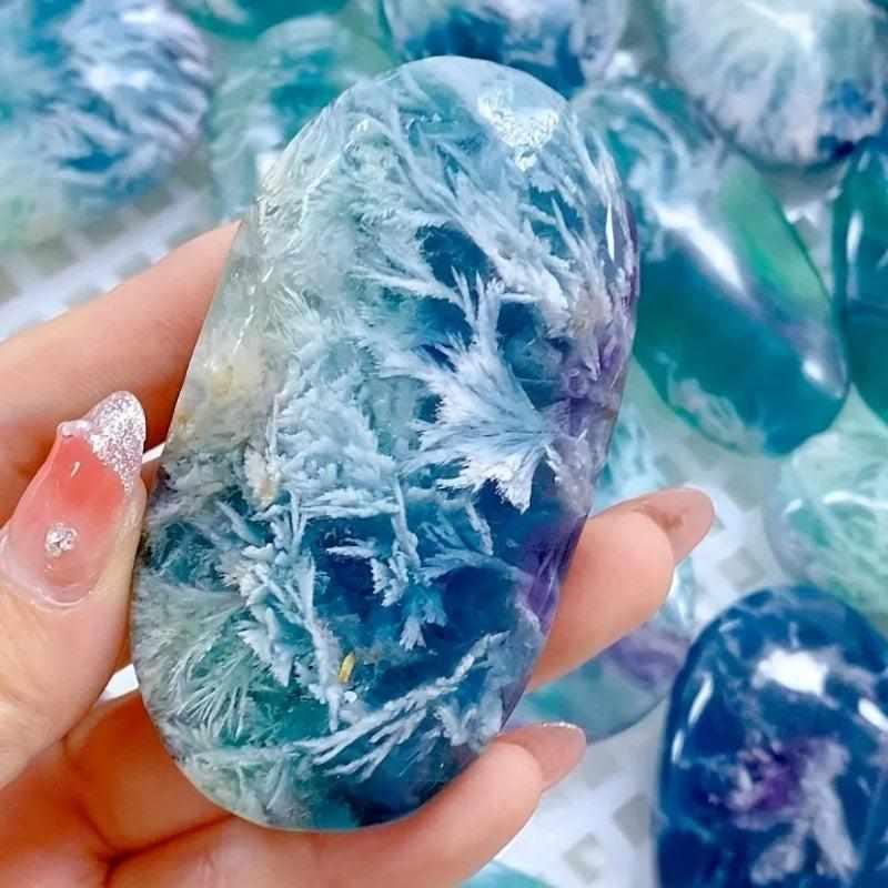 Polished feather fluorite palm stone for a crystal reading nook