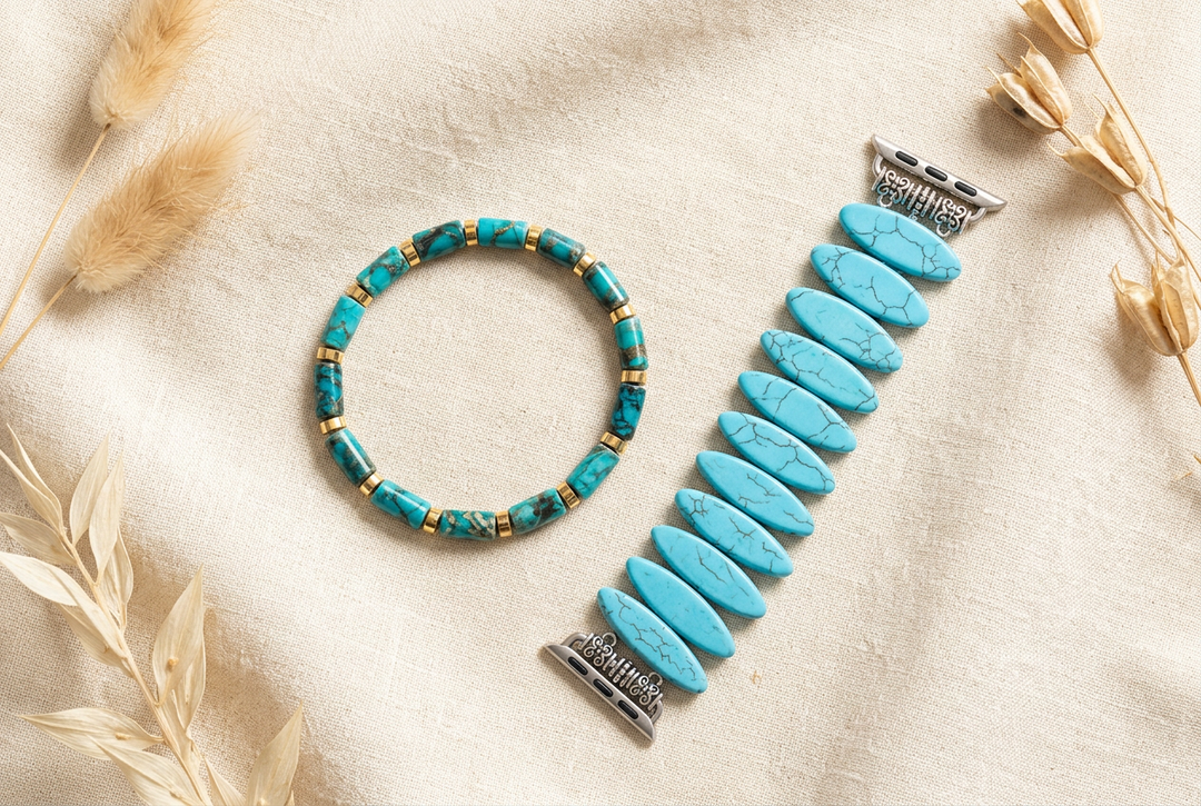 African turquoise barrel-bead bracelet and turquoise howlite oval-bead watch band on cream linen with dried botanicals.