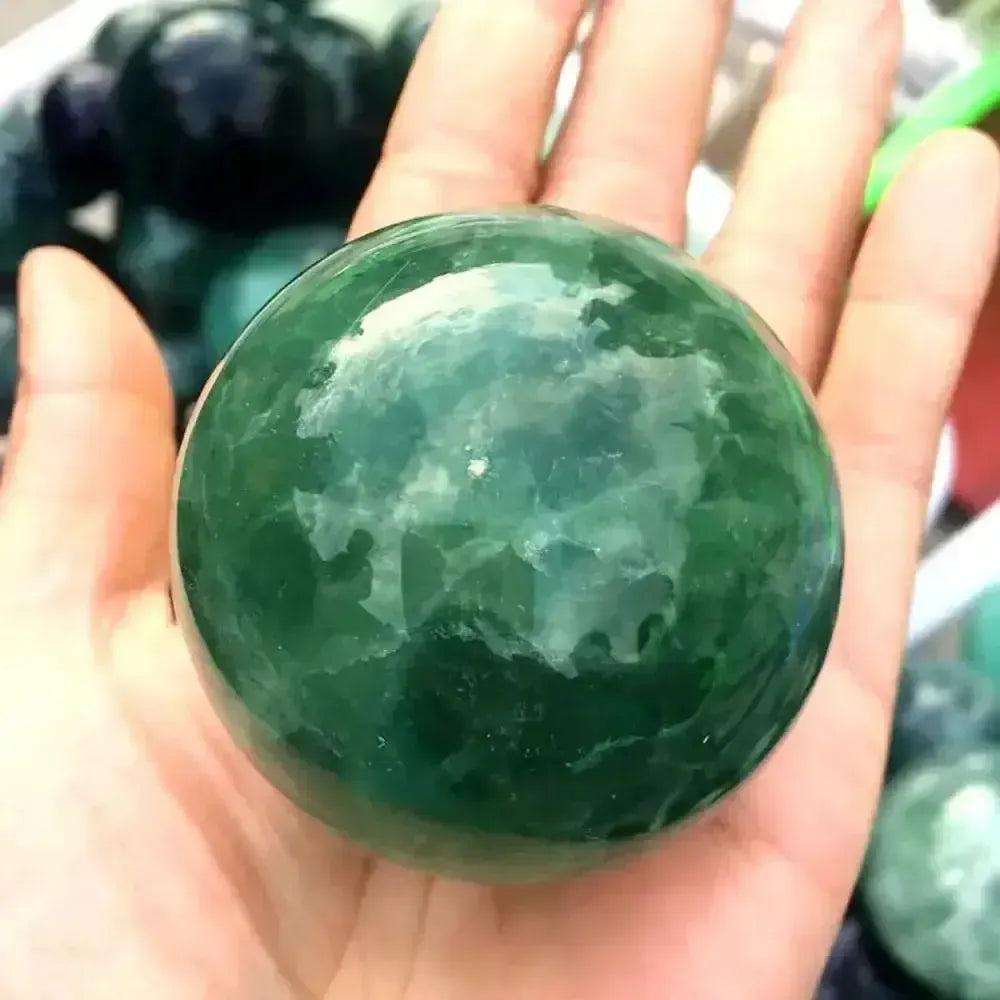 Healing Crystals for Every Purpose collection: Green crystal sphere in hand at Crystal Destiny.