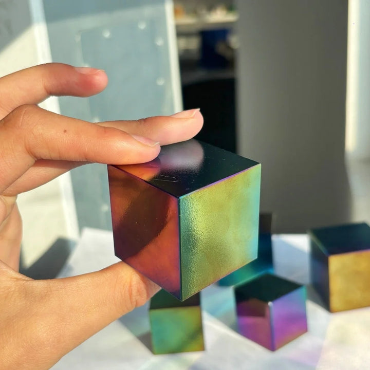 Polished natural obsidian cube with a vibrant, iridescent rainbow finish for spiritual grounding and bohemian decor.