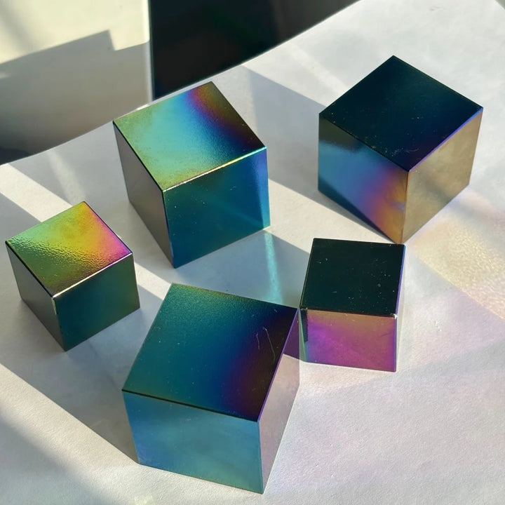 Polished natural obsidian cubes featuring a vibrant, iridescent rainbow finish for spiritual energy and bohemian decor.