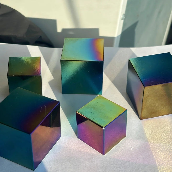 Polished natural obsidian cubes with a vibrant, iridescent rainbow finish for spiritual healing and bohemian decor.