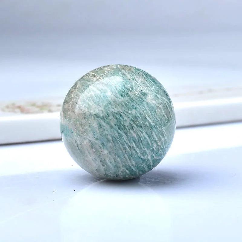 Polished natural Amazonite sphere, a blue-green crystal ball for Reiki healing and home decor.