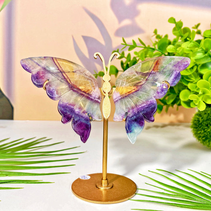 High-quality crystal butterfly wing with stand, featuring vibrant purple, yellow, and clear hues for healing and decoration.