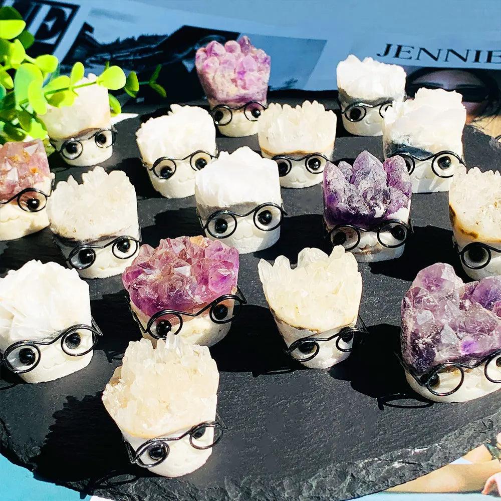 Natural amethyst and quartz crystal cluster ornaments shaped like cute characters wearing glasses for desk decor.