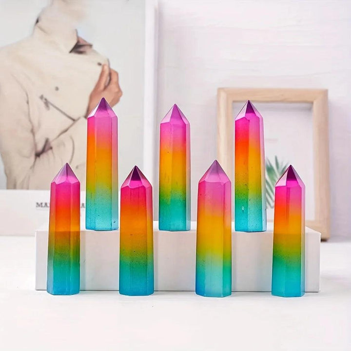 Rainbow aura selenite pillars with vibrant pink, yellow, and blue iridescent metallic colors for healing.