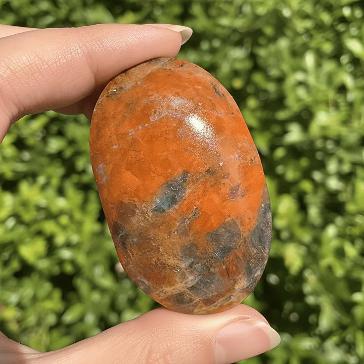 Polished Blue Apatite with Sunstone palm stone showing vibrant orange and blue healing crystals.