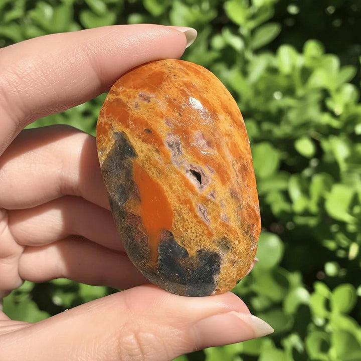 Polished Blue Apatite with Sunstone palm stone showing vibrant orange and blue-grey healing crystals.