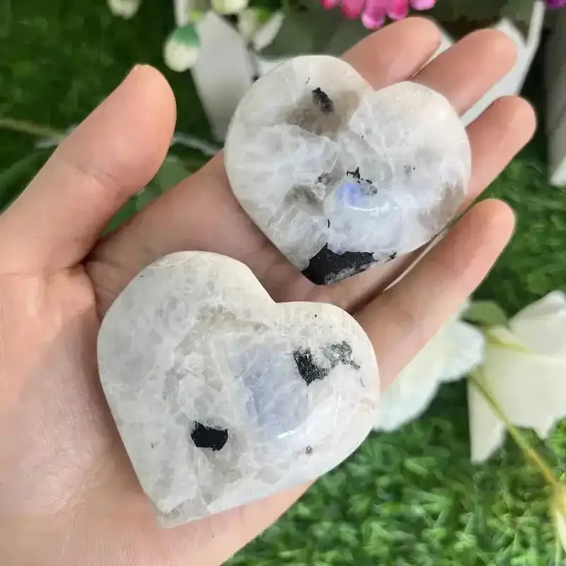 Two polished natural moonstone heart carvings with black inclusions, perfect for reiki healing and elegant home decor.