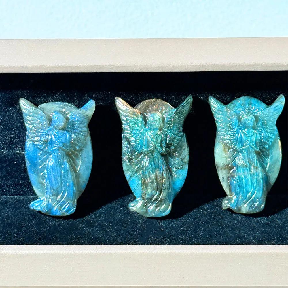 Three hand-carved Labradorite angel figurines with iridescent blue flashes, perfect for healing home decor and jewelry.
