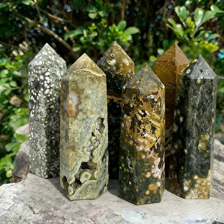 Natural Ocean Jasper crystal pillars in earthy green, brown, and grey tones with unique orbicular patterns.