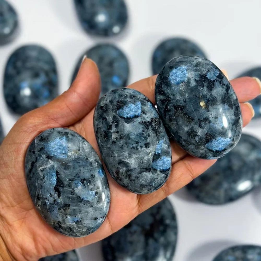 Polished blue and grey Larvikite palm stones with shimmering flashes for healing and home decor.