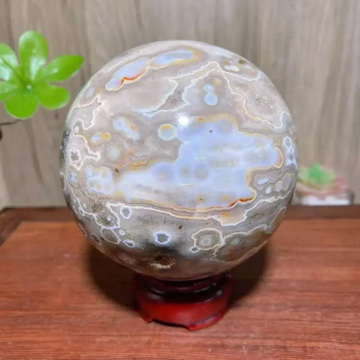 8th Vein Ocean Jasper geode sphere from Crystal Destiny, featuring white, blue, and orange orbicular patterns.