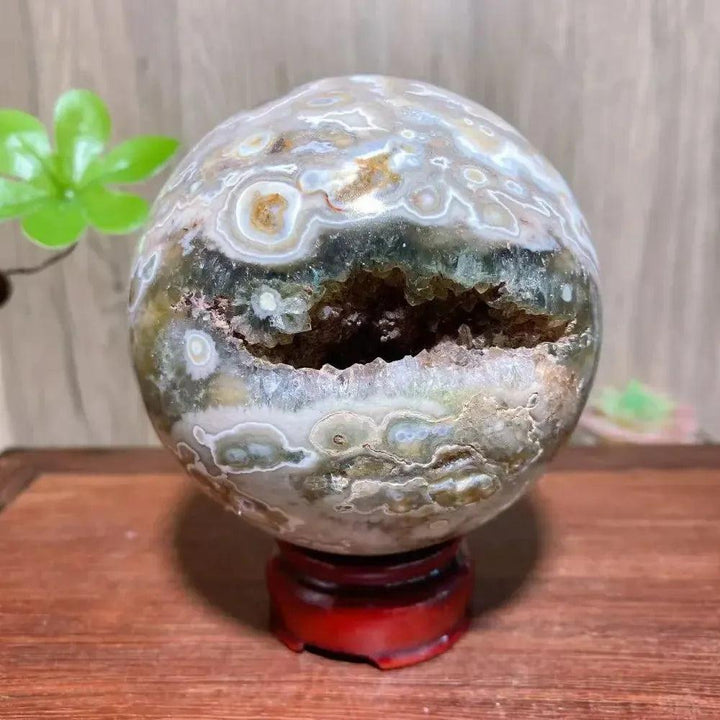 8th Vein Ocean Jasper geode sphere from Crystal Destiny, featuring green, white, and brown orbicular patterns with sparkling druzy.