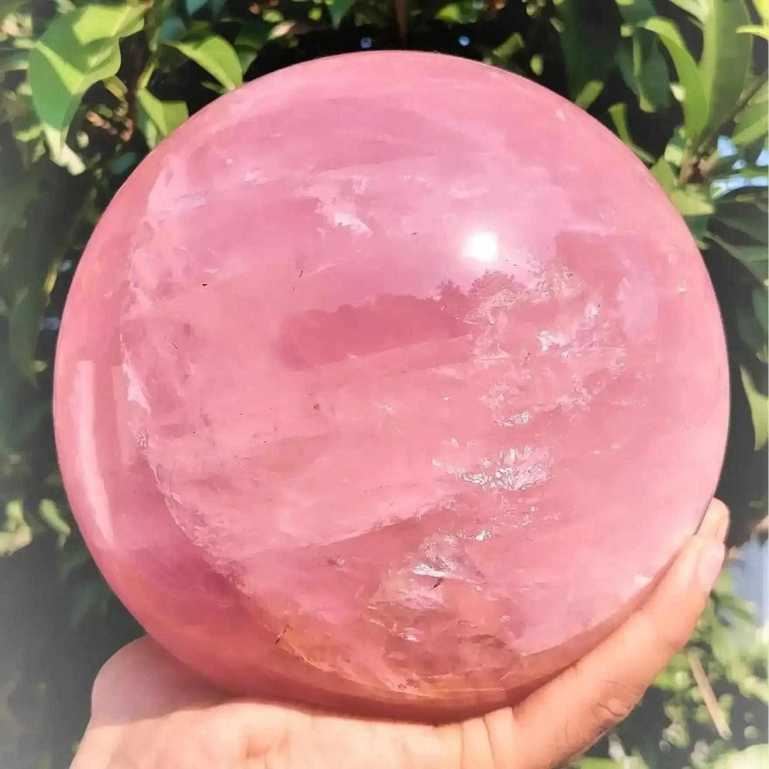 Large deep pink rose quartz crystal ball, a polished natural stone sphere perfect for romantic decor and healing energy.