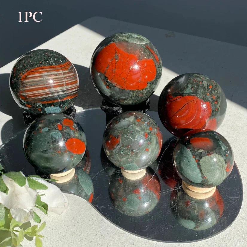 Polished African Bloodstone spheres with deep green and vivid red iron spots, varying in size from 50-85mm.