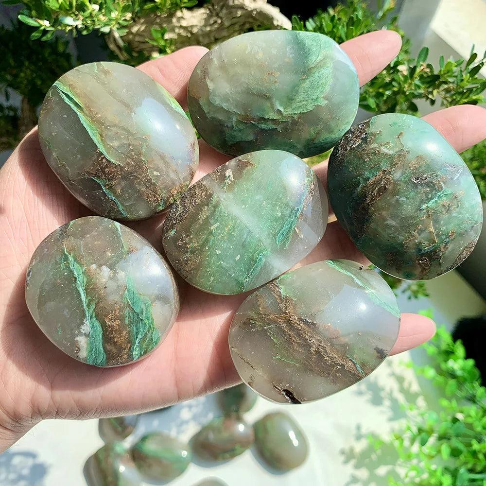 Polished African Jade Crystal Palm Stones with grounding green and brown veins for heart chakra healing.