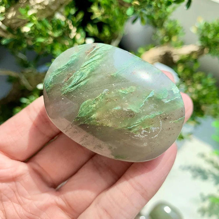Polished African Jade Crystal Palm Stone with grounding green inclusions, held in hand for heart chakra healing.