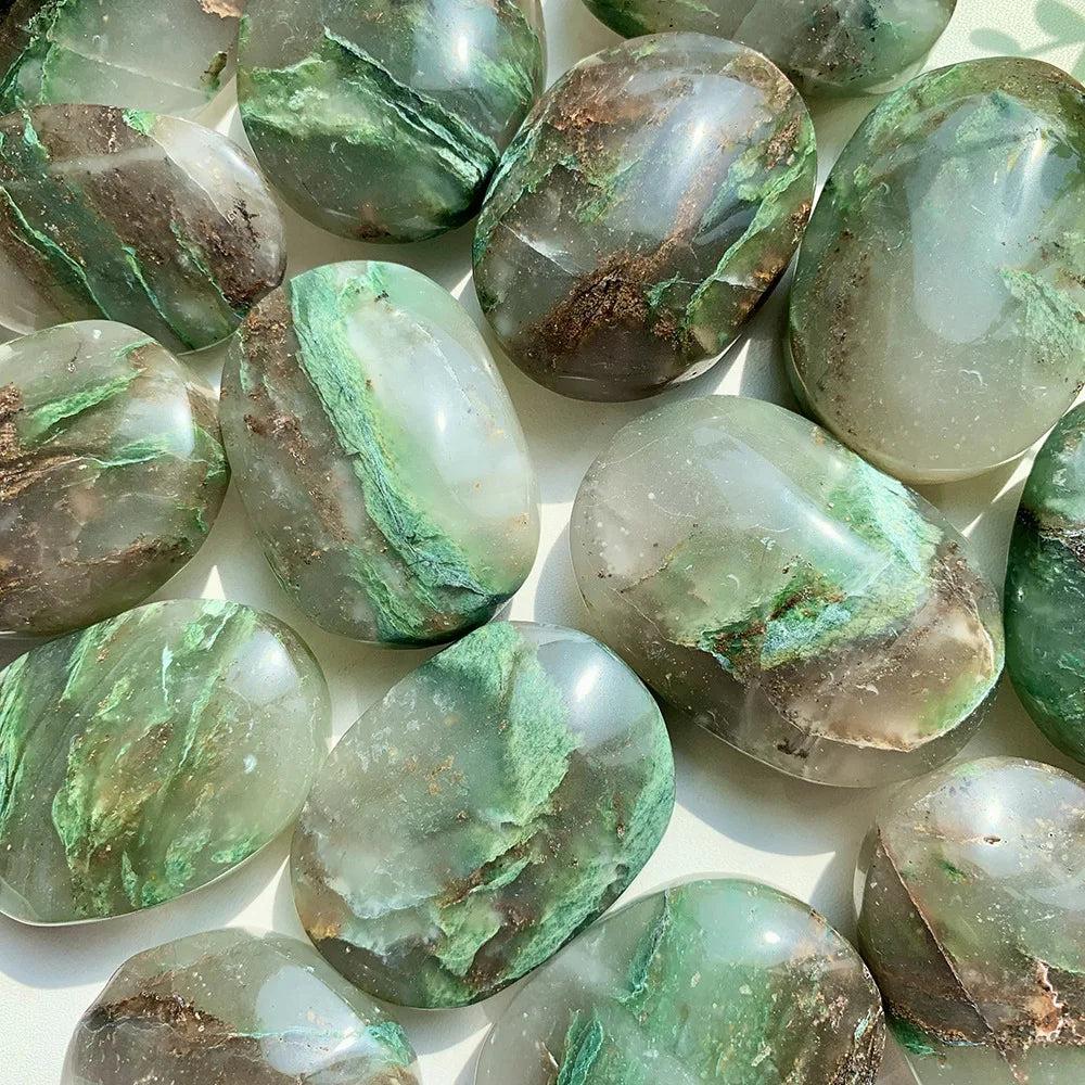 Polished African Jade Crystal Palm Stones in earthy green and brown tones for grounding energy.