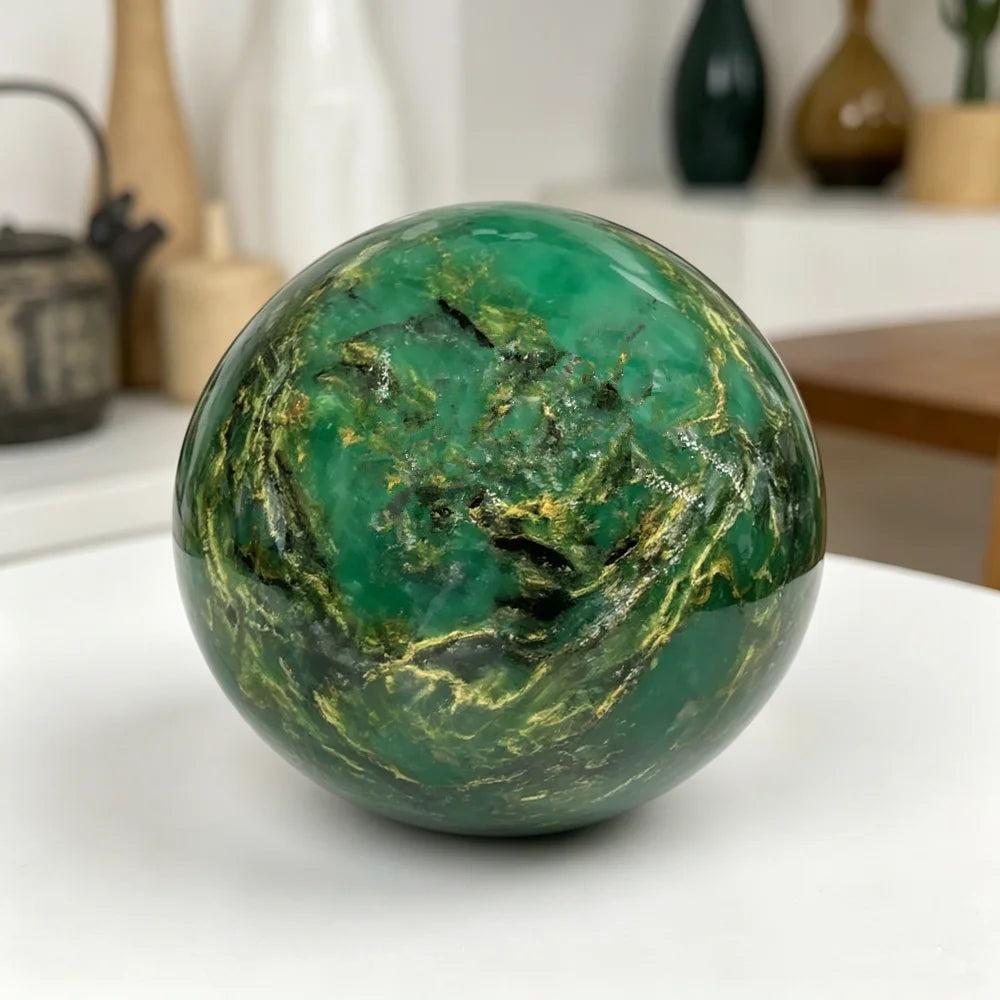 Polished 50-60mm African Verdite sphere in deep green with natural gold veining for grounding and heart chakra healing.