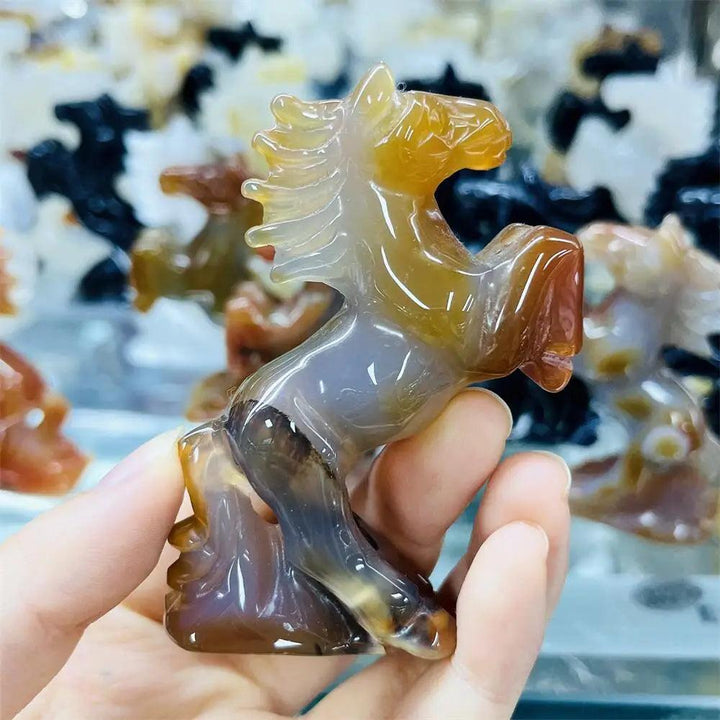 Hand-carved polished agate horse sculpture with earthy, translucent banding for grounding and steady energy.