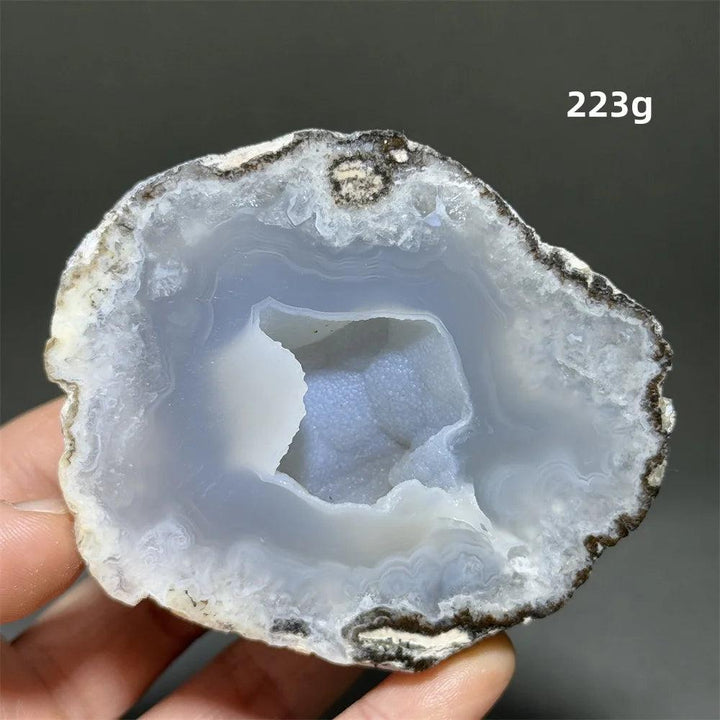 Natural Agate crystal geode slice with a pale blue druzy interior, promoting calm and spiritual connection.