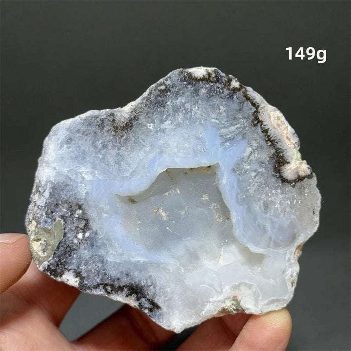 Natural Agate geode specimen with a sparkling white druzy crystal cave interior, held in a hand.