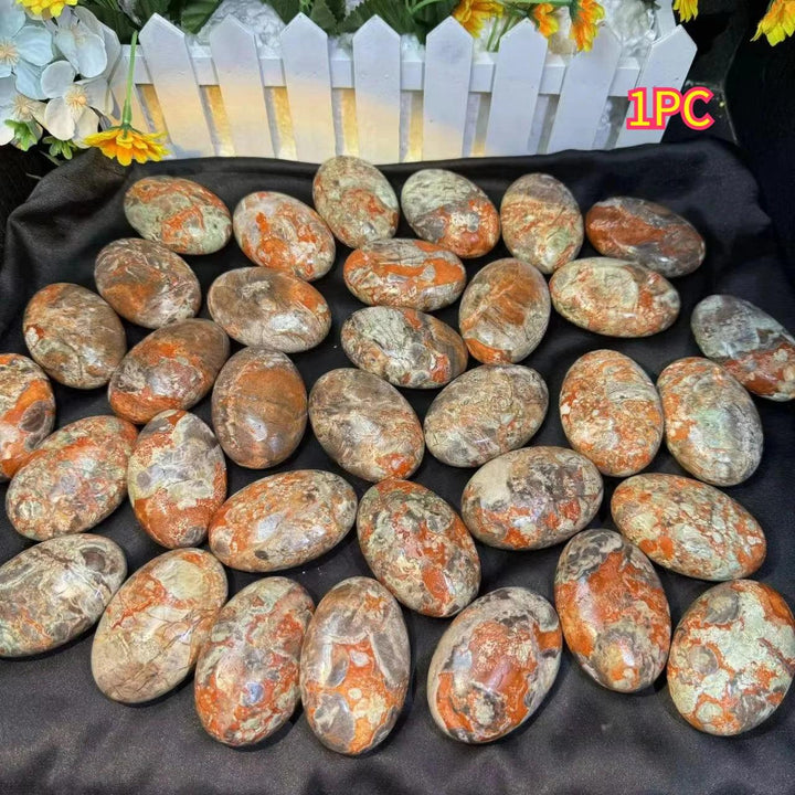 Polished agate palm stones featuring earthy red and green banded patterns for grounding, stability, and healing energy.