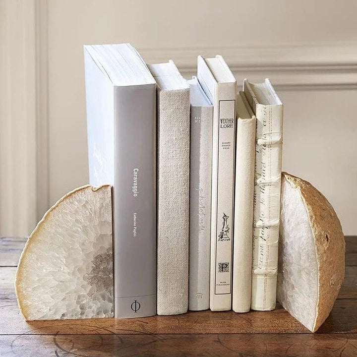 Polished natural agate crystal bookends in an abstract, irregular shape, grounding a row of books.