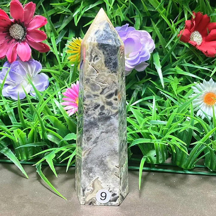 Polished Agate crystal tower with intricate grey banding for grounding, displayed against a vibrant floral background.