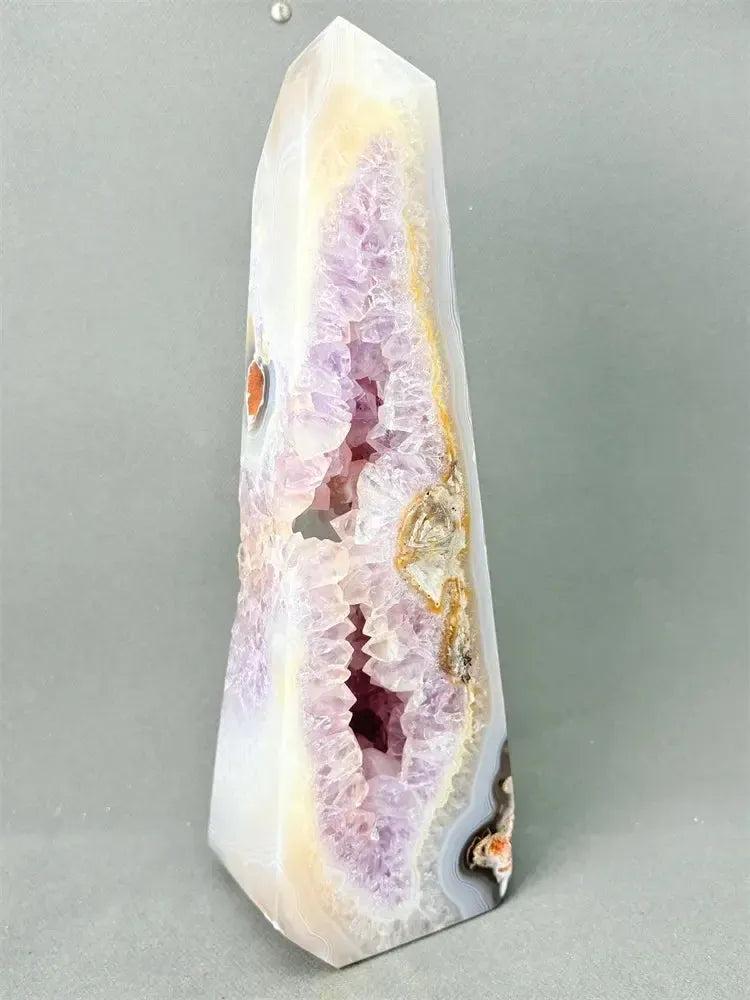 Polished Agate geode crystal tower with a sparkling purple druzy cave and earthy banded exterior.