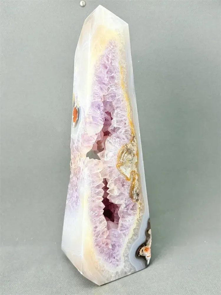 Polished Agate geode crystal tower with a sparkling purple druzy cave and earthy banded exterior.