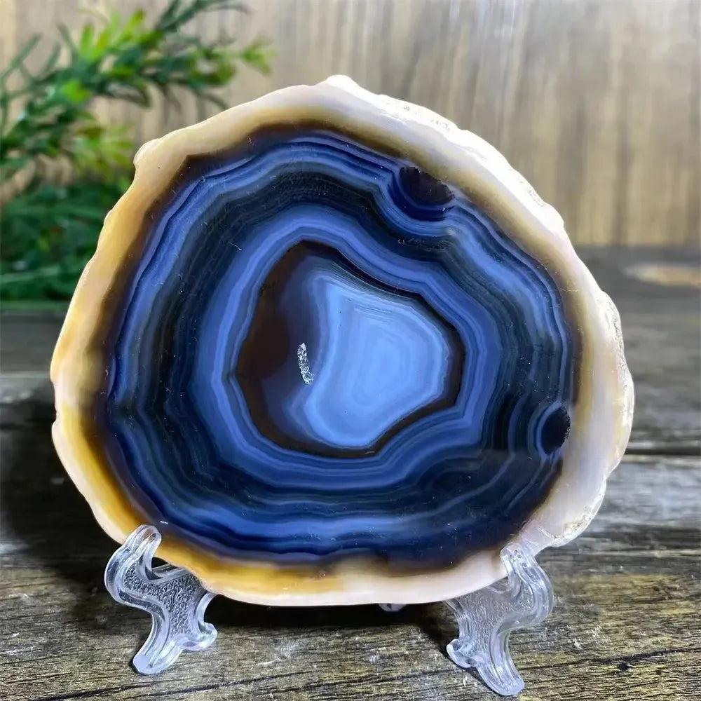 Crystal Destiny's blue banded agate slice on a stand, showcasing natural patterns for grounding energy.