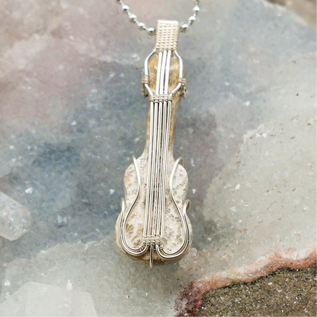 Agatized Coral Violin Wire Wrap Pendant: Handcrafted copper wire violin with a fossilized coral stone, promoting ancient wisdom.