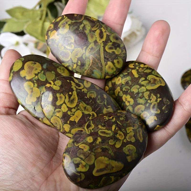 Polished Ajooba Jasper palm stones with earthy yellow and brown swirls for grounding and stability.