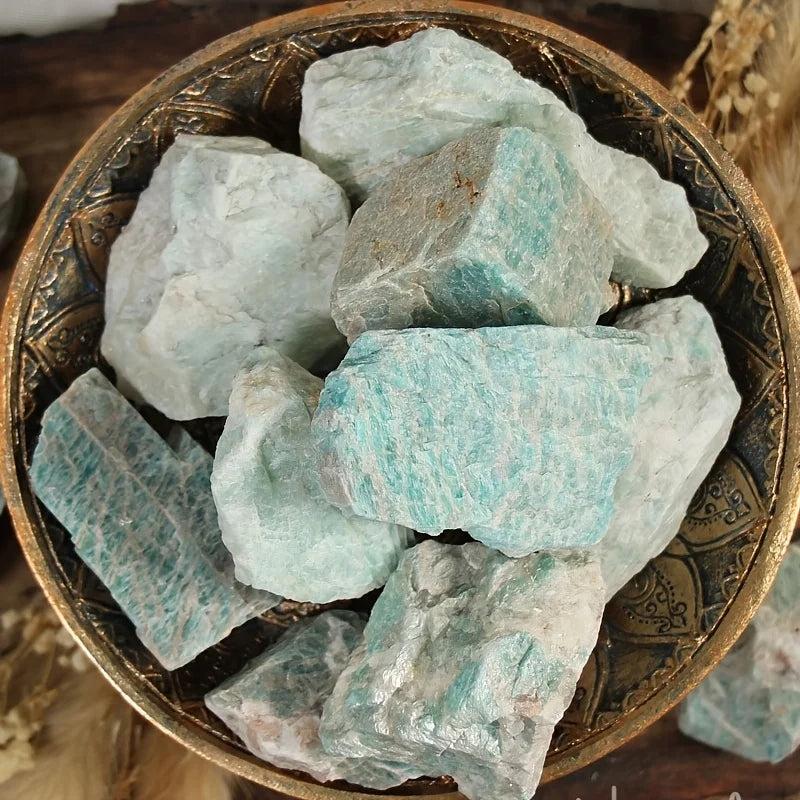 Raw Amazonite crystal chunks in a decorative bowl, featuring natural blue-green textures for healing and grounding energy.