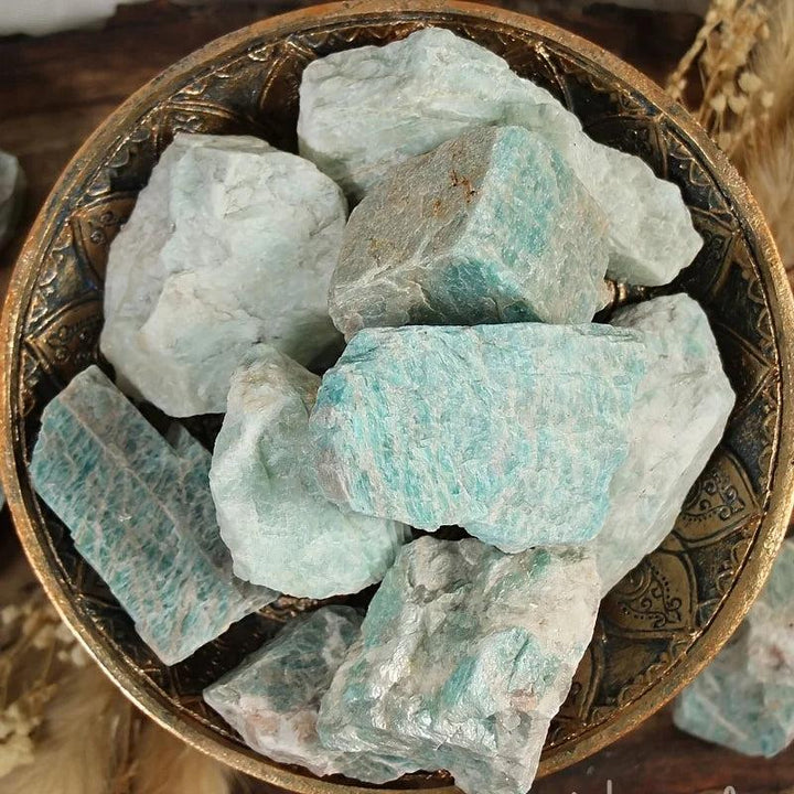 Raw Amazonite crystal chunks in a decorative bowl, featuring natural blue-green textures for healing and grounding energy.