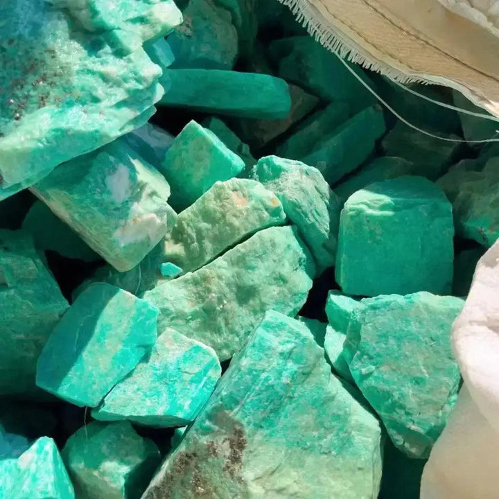 Raw Amazonite crystals in varying turquoise-green hues, showcasing organic textures and natural beauty.