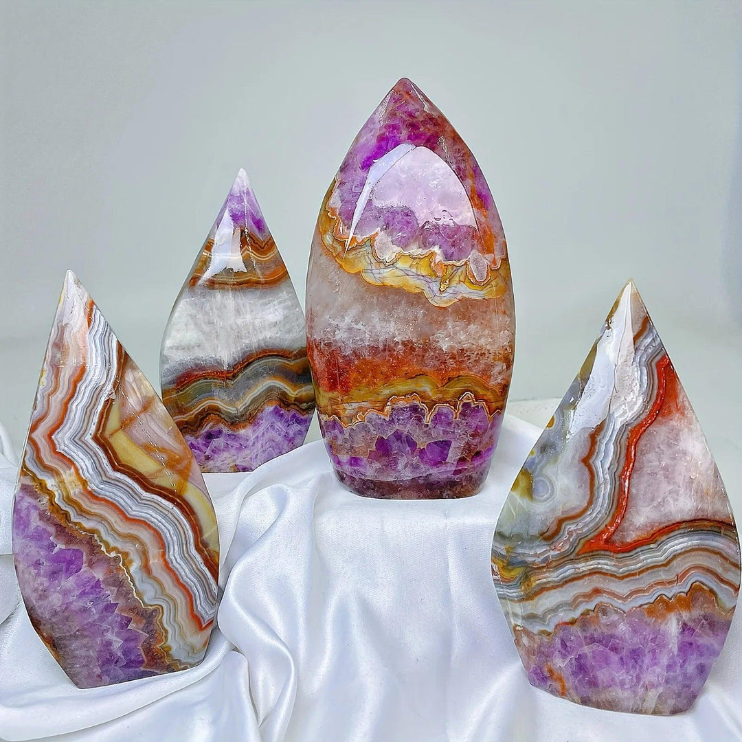 Four polished Amethyst Agate crystal freeforms in varying sizes, displaying vibrant violet, white, orange, and yellow bands.