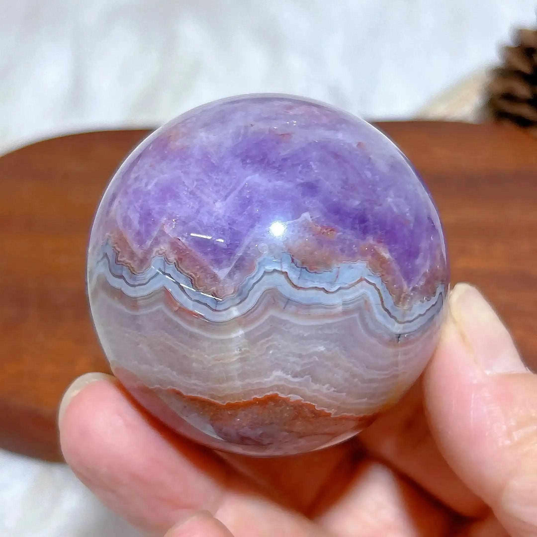 Hand-polished Amethyst Agate sphere featuring purple amethyst and banded white, gray, and brown patterns for meditation.