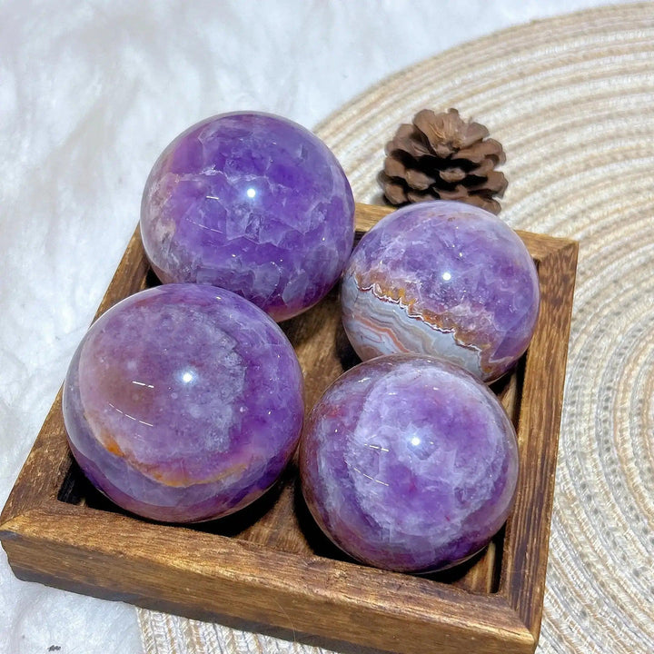 Four polished Amethyst Agate spheres featuring purple hues and banded patterns for peaceful focus and Crown Chakra healing.