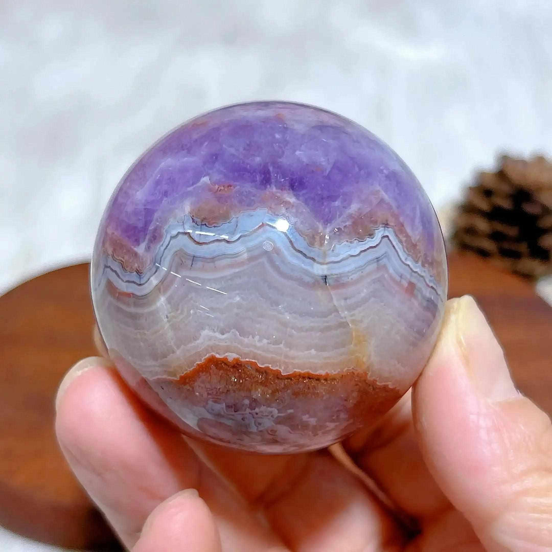Hand-polished Amethyst Agate sphere featuring purple amethyst and banded white, gray, and brown patterns for meditation.