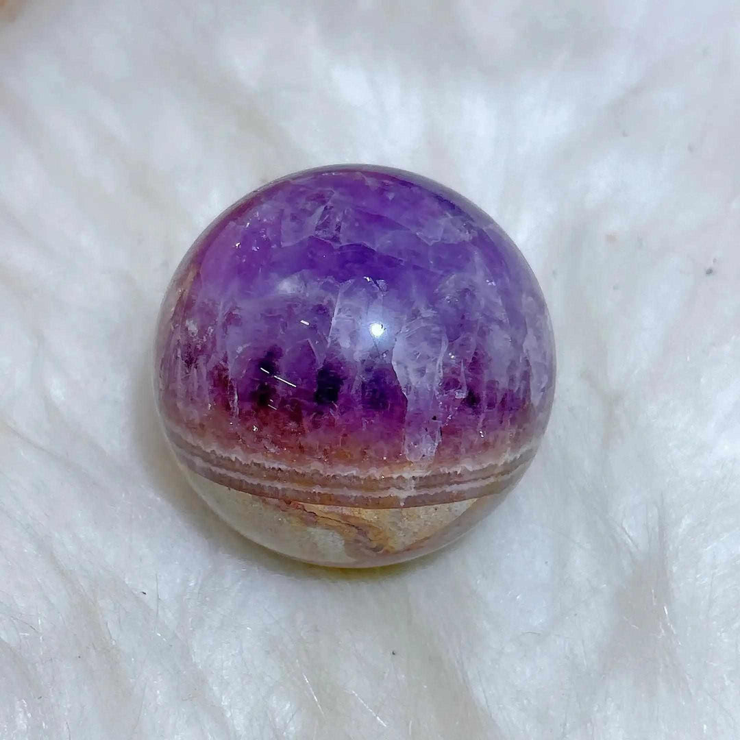 Polished Amethyst Agate sphere featuring vibrant purple hues and banded white and brown layers for peaceful meditation.