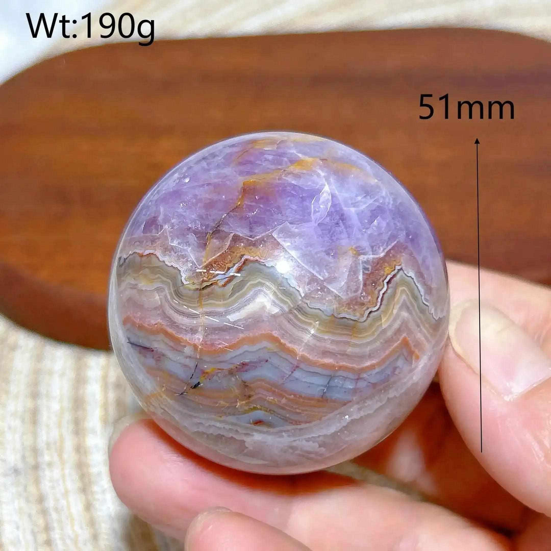 Hand-polished 51mm Amethyst Agate sphere featuring purple amethyst and banded white, gray, and brown patterns for focus.