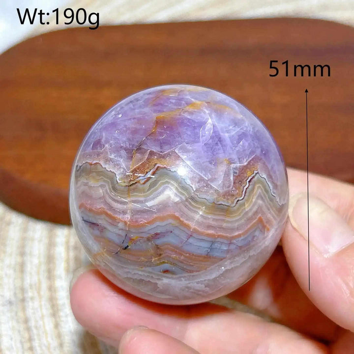 Hand-polished 51mm Amethyst Agate sphere featuring purple amethyst and banded white, gray, and brown patterns for focus.
