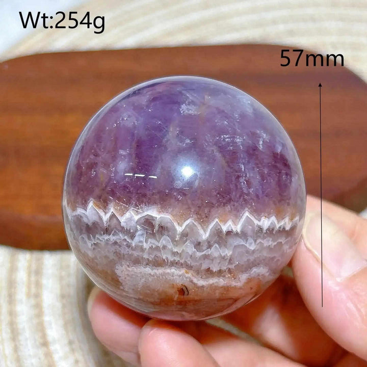 Hand-polished Amethyst Agate sphere featuring purple hues and white banded patterns for peaceful meditation and focus.
