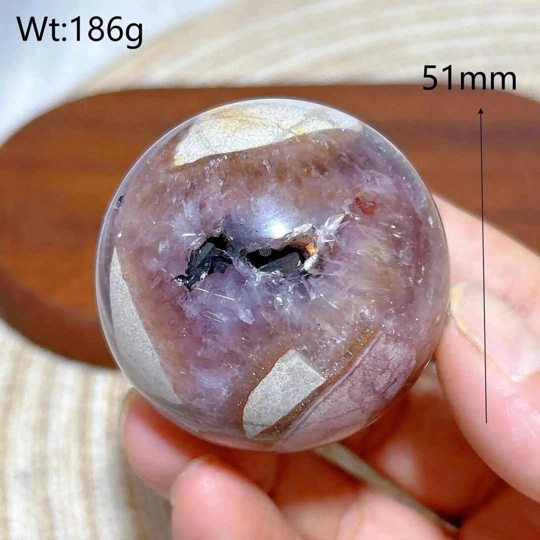 Hand-polished Amethyst Agate sphere featuring purple hues, banded patterns, and a calming crystal center for meditation.