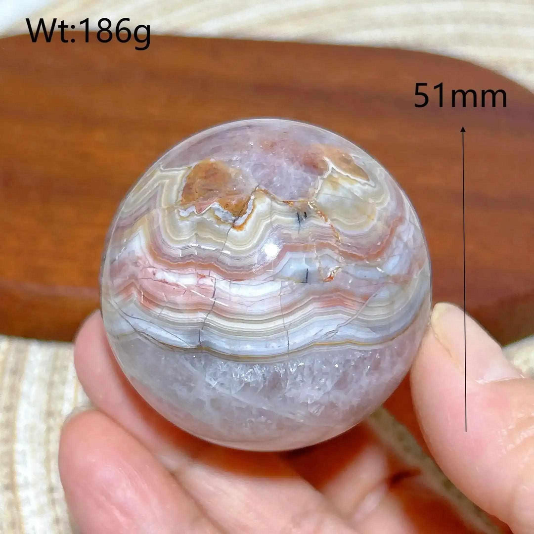 Hand-polished 51mm Amethyst Agate sphere featuring beautiful purple, gray, and brown bands for peaceful meditation focus.