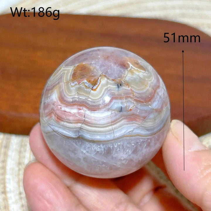Hand-polished 51mm Amethyst Agate sphere featuring beautiful purple, gray, and brown bands for peaceful meditation focus.
