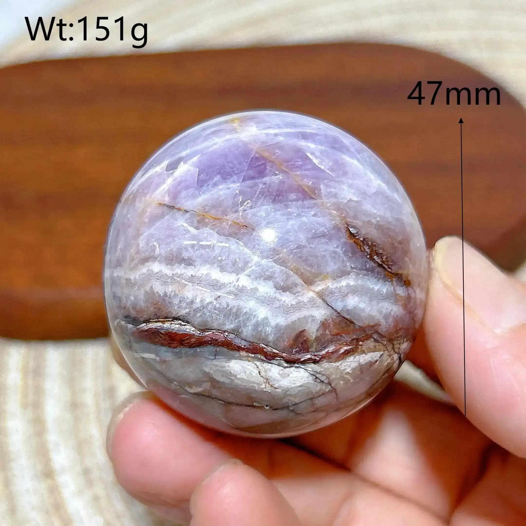 Hand-polished 47mm Amethyst Agate sphere featuring purple, white, and brown banded patterns for peaceful meditation focus.